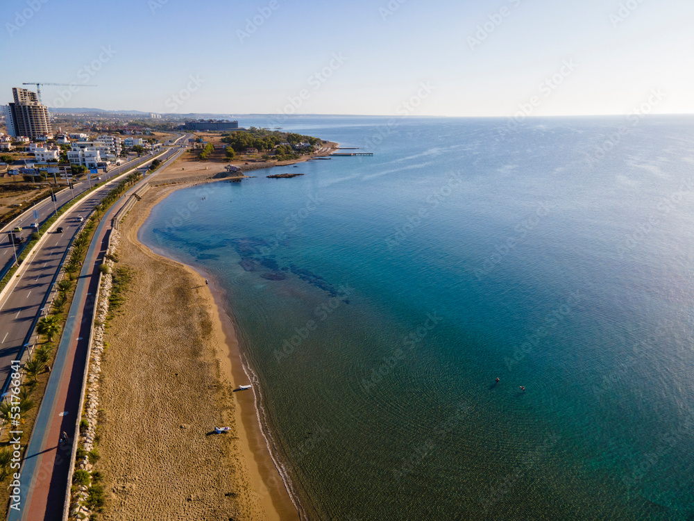 Beautiful beach in the background of the city. Cyprus, Long Beach. Blue lagoon of the Mediterranean Sea, highway. Beautiful beach in the background of the city. Cyprus, Long Beach. Blue lagoon of the Mediterranean Sea, highway.