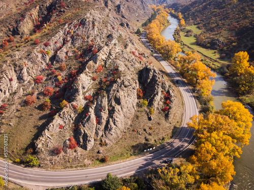 Foto Road near mountain river in autumn