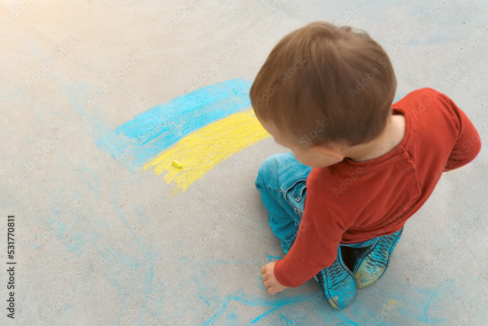 Child drawing Ukrainian flag on concrete floor. Chalk drawing on sidewalk. Support for Ukraine concept. Symbol of solidarity with Ukrainian nation Child drawing Ukrainian flag on concrete floor. Chalk drawing on sidewalk. Support for Ukraine concept. Symbol of solidarity with Ukrainian nation