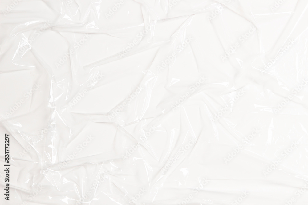 Wrinkled plastic wrap on white color background. Crumpled transparent plastic cellophane. Reflecting light and shadow on creases and folds in plastic surface. Texture overlay effect template Wrinkled plastic wrap on white color background. Crumpled transparent plastic cellophane. Reflecting light and shadow on creases and folds in plastic surface. Texture overlay effect template