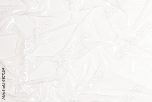 Wrinkled plastic wrap on white color background. Crumpled transparent plastic cellophane. Reflecting light and shadow on creases and folds in plastic surface. Texture overlay effect template