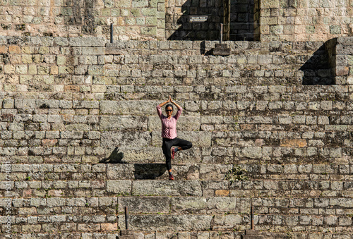 Yoga pose on the Ball Court at the Copan Mayan Ruins, Copan Ruinas, Honduras photo