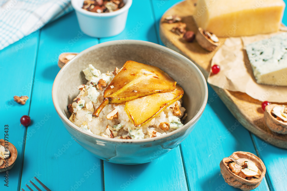 Pear and gorgonzola oatmeal with walnuts on blue wooden table Pear and gorgonzola oatmeal with walnuts on blue wooden table