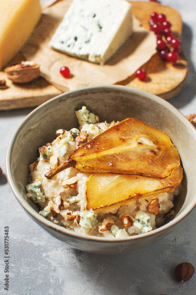 Pear and gorgonzola oatmeal with walnuts on concrete table Pear and gorgonzola oatmeal with walnuts on concrete table