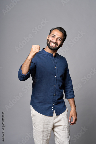 Happy excited rich successful indian professional business man leader investor executive winner raising fist isolated on gray background celebrating success,good work results achievements, Got new job