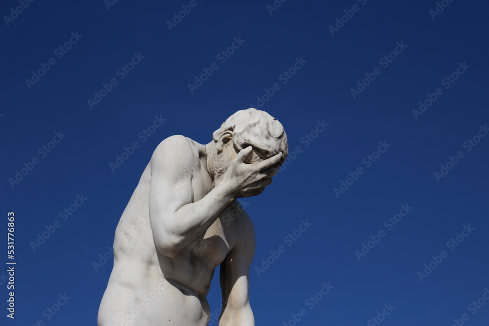Caïn by Henri Vidal, Tuileries Garden, Paris, 1896. Funny face palming statue background with copy space. Concept for frustration, failure, annoyance. Statue Cain coming from killing his brother Abel