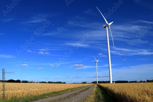 Wind turbine. Swedish green energy. One summer day outside. Fields, meadow and graveled road. Near Skara, Sweden, Scandinavia, Europe.