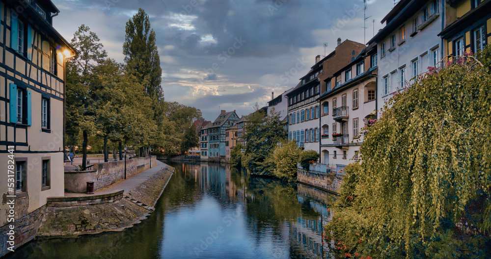 View of the old buildings on the riverbanks reflecting on water of river Ill, Strasbourg