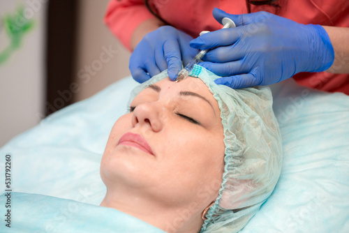 Injection facial rejuvenation. The cosmetologist injects cosmetic injections into the muscles of the face to smooth out wrinkles. Botox and collagen injections at the cosmetologist.