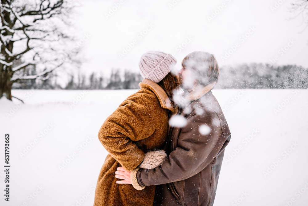 Cute young couple in love having fun in the winter park on bright day. Woman and man relaxing outdoors Cute young couple in love having fun in the winter park on bright day. Woman and man relaxing outdoors