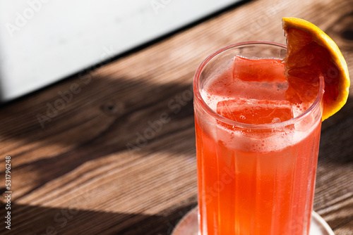 close up picture of grapefruit garibaldi cocktail in a highball glass