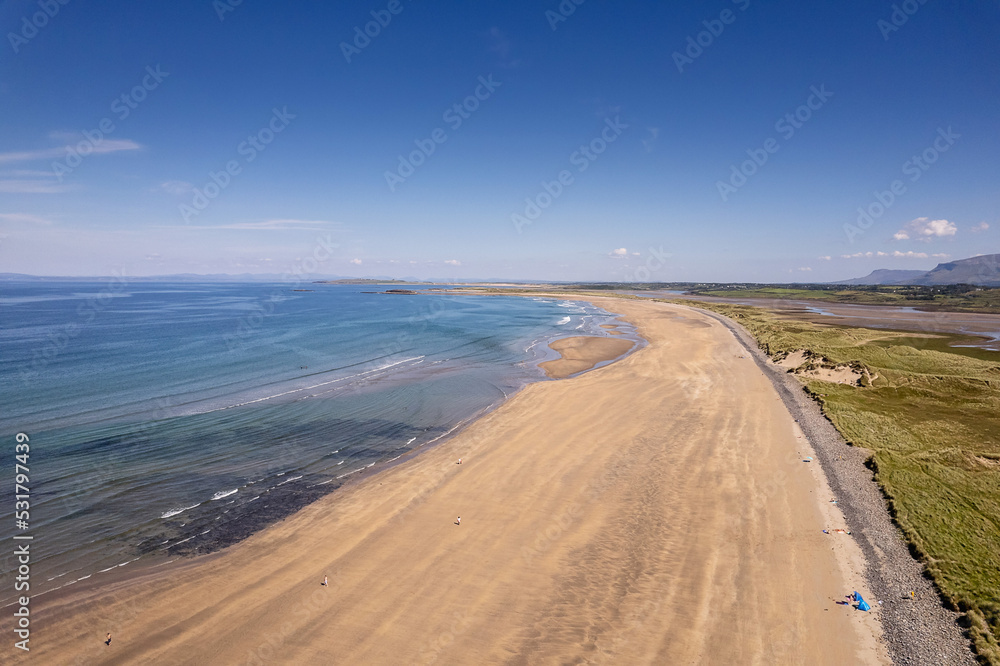 Aerial view on Streedagh beach in county Sligo, Ireland. Beautiful nature scene with warm yellow sand and blue ocean and clear blue sky. Popular tourist area. Warm sunny day.