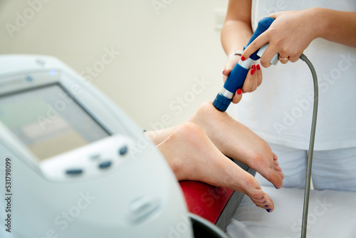 Quadro su tela Doctor neurologist using shockwave to relieve pain heel spur