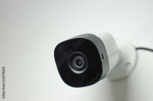 CCTV videocam, CFTV security camera, white camera with secure circuit, theft protection. Surveillance view.