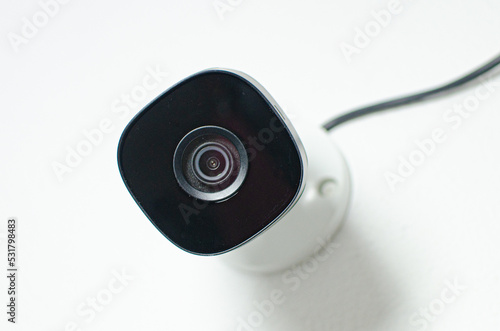 CCTV videocam, CFTV security camera, white camera with secure circuit, theft protection. Surveillance view.