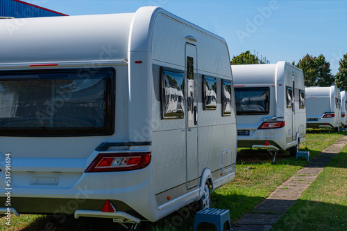 A row of touring caravans on standing on a sunny day in summer.