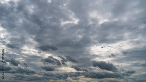 Timelapse gray rainy clouds float across the dark sky on a cloudy day. Cloudy sky and gloomy clouds. Magic dramatic sky in rainy weather. Ominous clouds slowly drift across the sky, threatening rain. photo