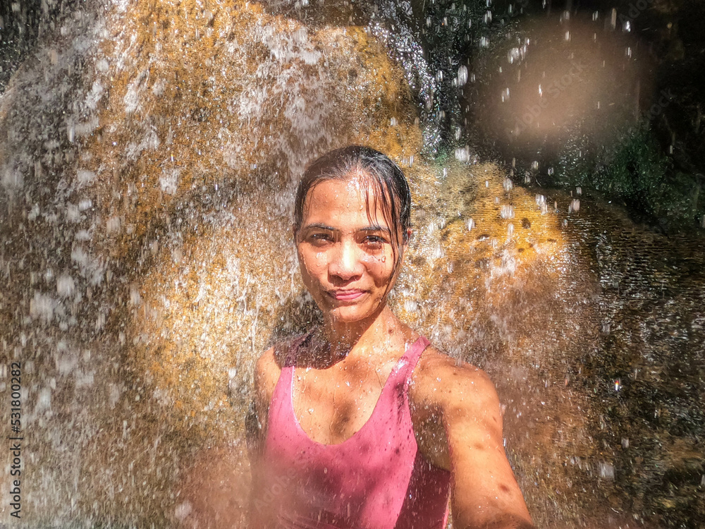 Fototapeta premium Tourist enjoying the hot spring waterfall of Finca Paraiso, Rio Dulce, Guatemala