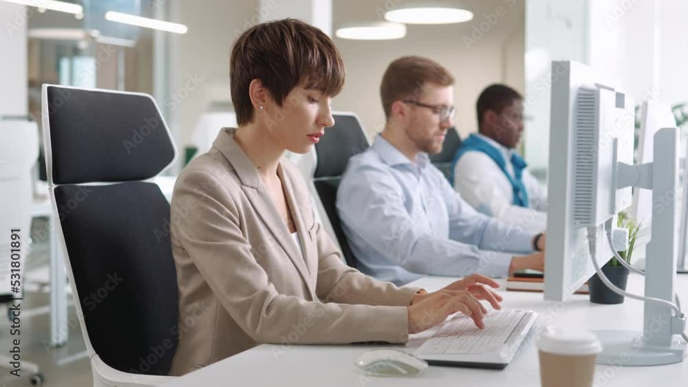 Multi-ethnic young people work in office typing on computer. Beautiful woman and handsome men sitting at desk and coding on computer indoor. IT specialist job. Close up. Business concept Multi-ethnic young people work in office typing on computer. Beautiful woman and handsome men sitting at desk and coding on computer indoor. IT specialist job. Close up. Business concept