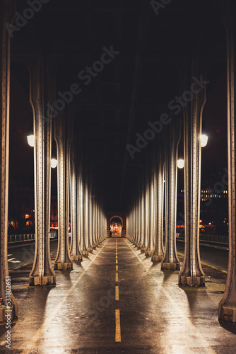 Panoramic view of old historic Bir Hakeim Bridge (formerly the Pont de Passy) in Paris, France. Steel arch bridge viaduct symmetry tunnel across river Seine. Street lights and colonnade.