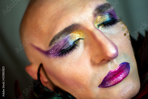 Closeup glamorous portrait of gender fluid person wearing bright makeup, eyes closed