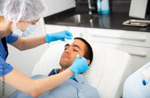 Portrait of male patient during cosmetology procedure in beauty clinic  getting carbon dioxide injections for face skin rejuvenation
