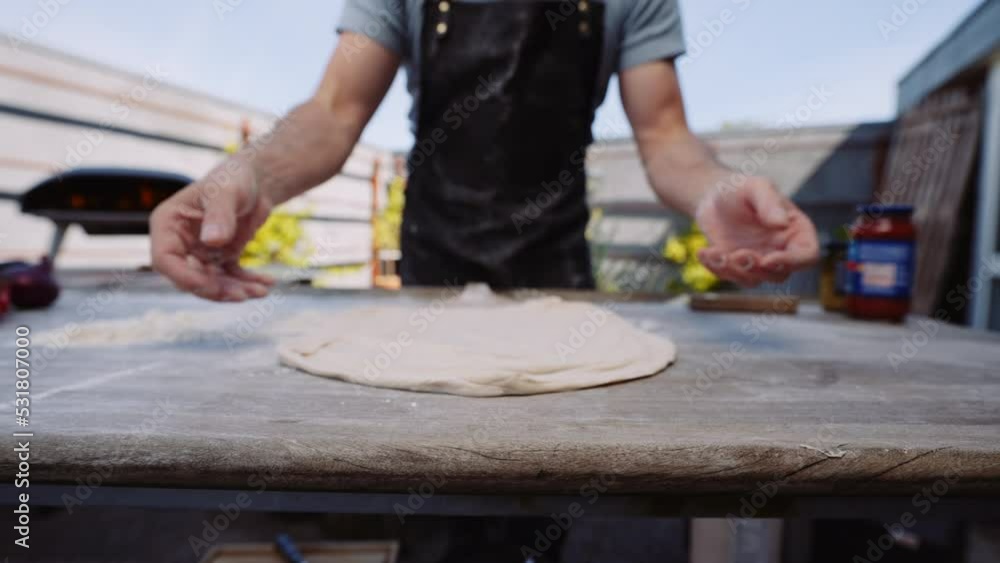Man Placing Pizza Base Dough Onto Pizza Paddle On Table Man Placing Pizza Base Dough Onto Pizza Paddle On Table