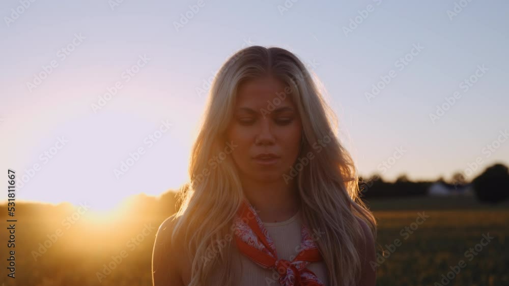 Beautiful Young Woman Walking Through the Wheat Field in Soft Lights of Sunset Beautiful Young Woman Walking Through the Wheat Field in Soft Lights of Sunset