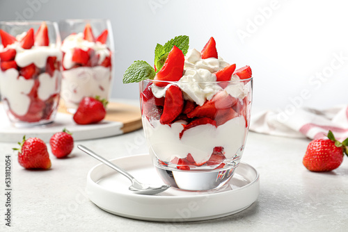 Obraz na płótnie Delicious strawberries with whipped cream served on light grey table