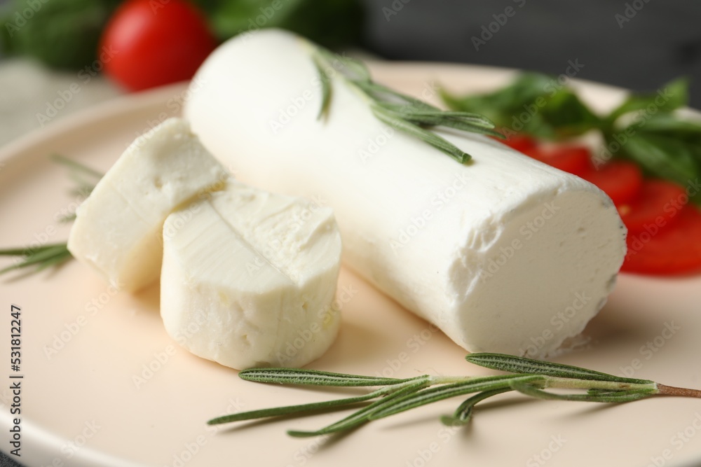 Delicious goat cheese with rosemary on plate, closeup