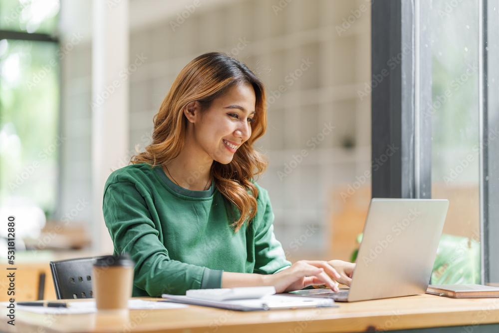 Attractive pretty asian business woman working on laptop at workstation office workplace. Attractive pretty asian business woman working on laptop at workstation office workplace.
