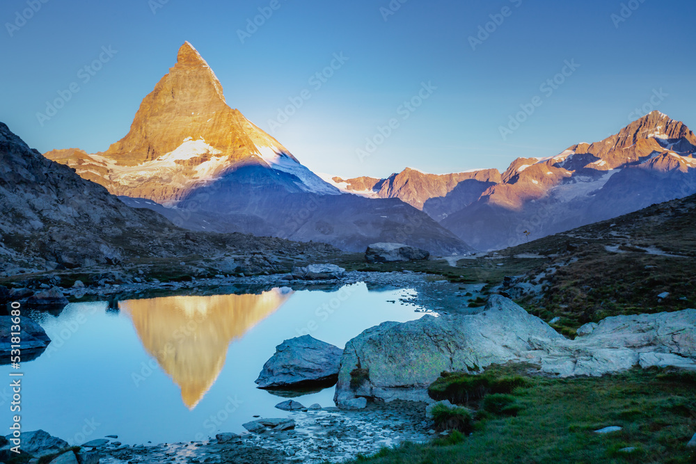 Matterhorn iconic mountain and lake relfection at peaceful sunrise, Swiss Alps