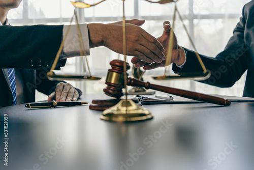 Lawyers shake hands with businessmen to make a deal. legal advisor Various contract consulting services to plan court proceedings with scales and hammers placed beside