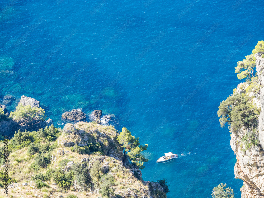 Lone boat at sea cliffs at Amalfi Coast in Italy