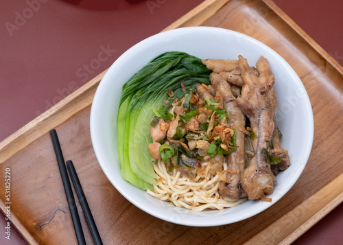 Mie ayam ceker (Chicken noodle with tasty chicken feet), Indonesian street food consist of noodle, vegetables, chicken meat and chicken feet. Popular food in the country photo