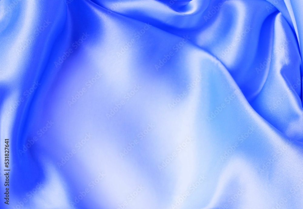 Obraz premium Beautiful light blue material folded into folds. Silk, satin. Solid background.