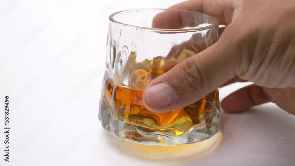 Chef holding a glass of liquor on a close-up white background table. Chef holding a glass of liquor on a close-up white background table.
