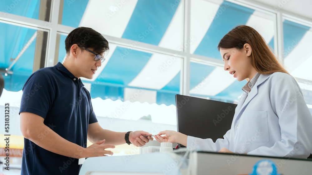 Pharmacist Chayong standing and talking to the patient Buying medicines with a credit card online spending Pharmacist Chayong standing and talking to the patient Buying medicines with a credit card online spending