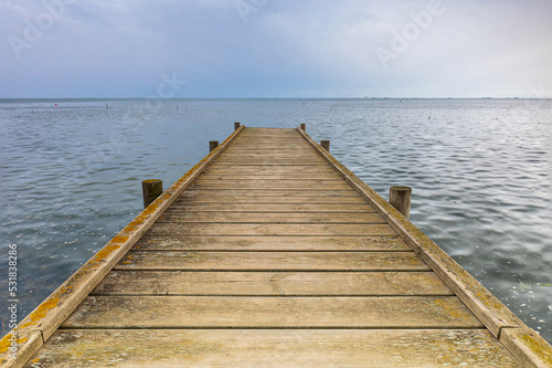 Pier that goes into the sea with the horizon in the background. End of summer concept