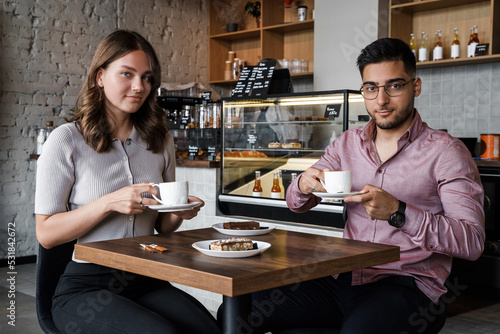 Shot of woman with her boyfriend relaxing drinking coffee in modern coffee shop.