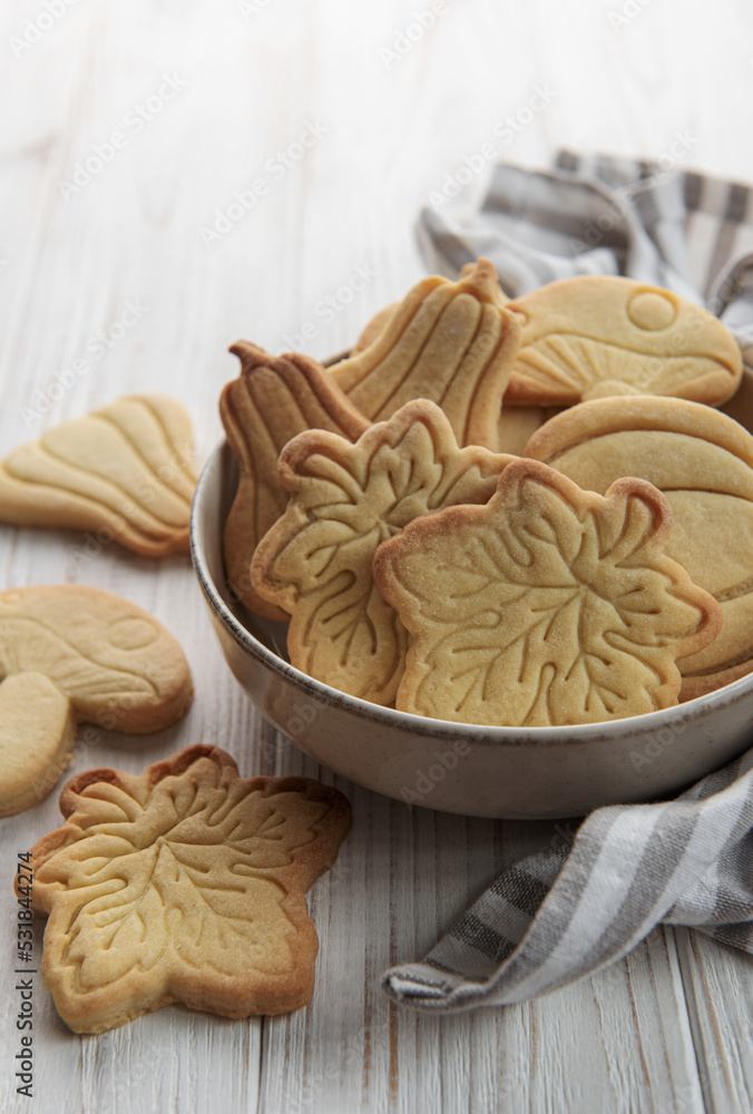 Cookies shaped like pumpkin and leaves on rustic wood background Cookies shaped like pumpkin and leaves on rustic wood background