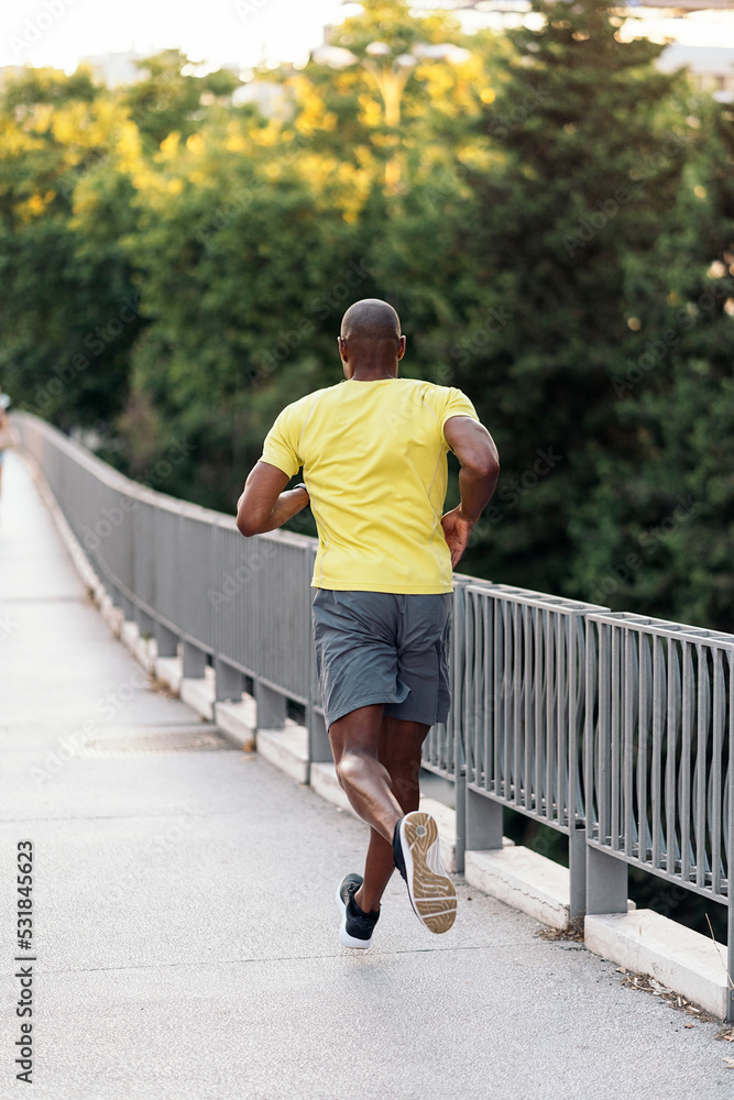 Obraz premium Unrecognizable man jogging on sidewalk in the city outdoors