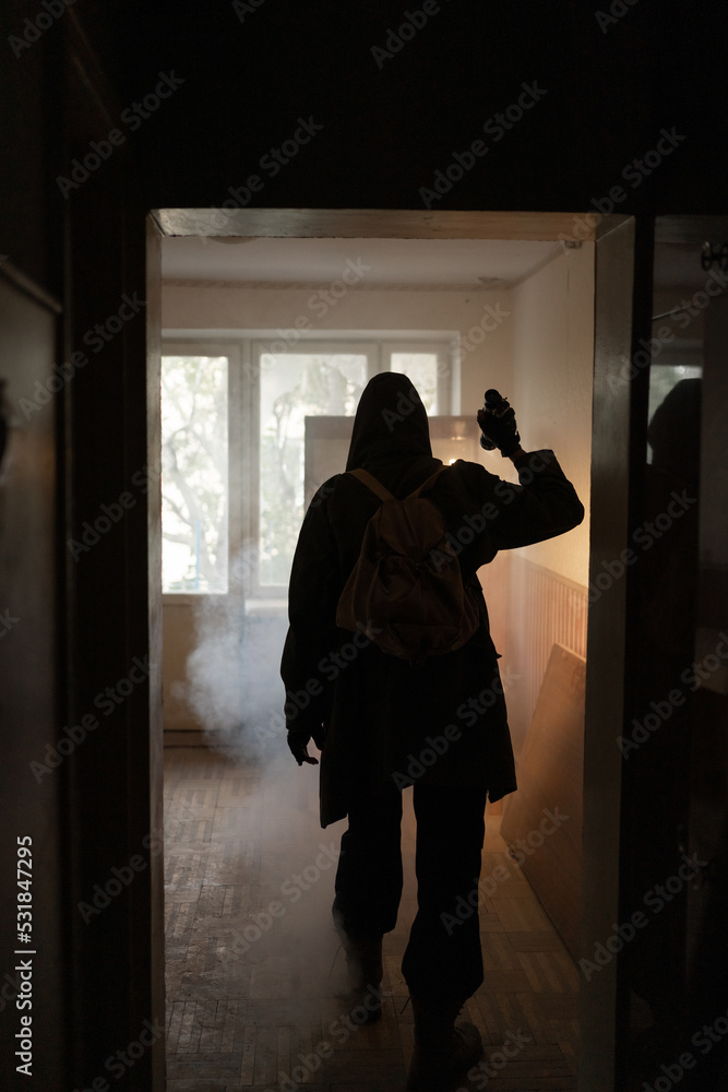 woman against the background of a window in a ruined house and shining flashlight, horror, fear concept, radiation stalker in Chernobyl zombie apocalypse, post apocalyptic survivor