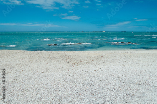 Wide and empty white sandy beach and seaside in sunny weather photo