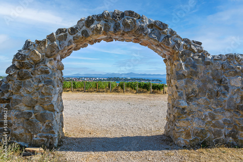 View of the vineyards of Croatia through a stone arch