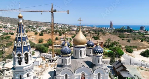 Aerial drone footage of the construction of Russian orthodox church Saint Nicholas in Limassol, Cyprus.Reveal scene of the golden dome, bell tower, cross of religious russian architecture from above. photo