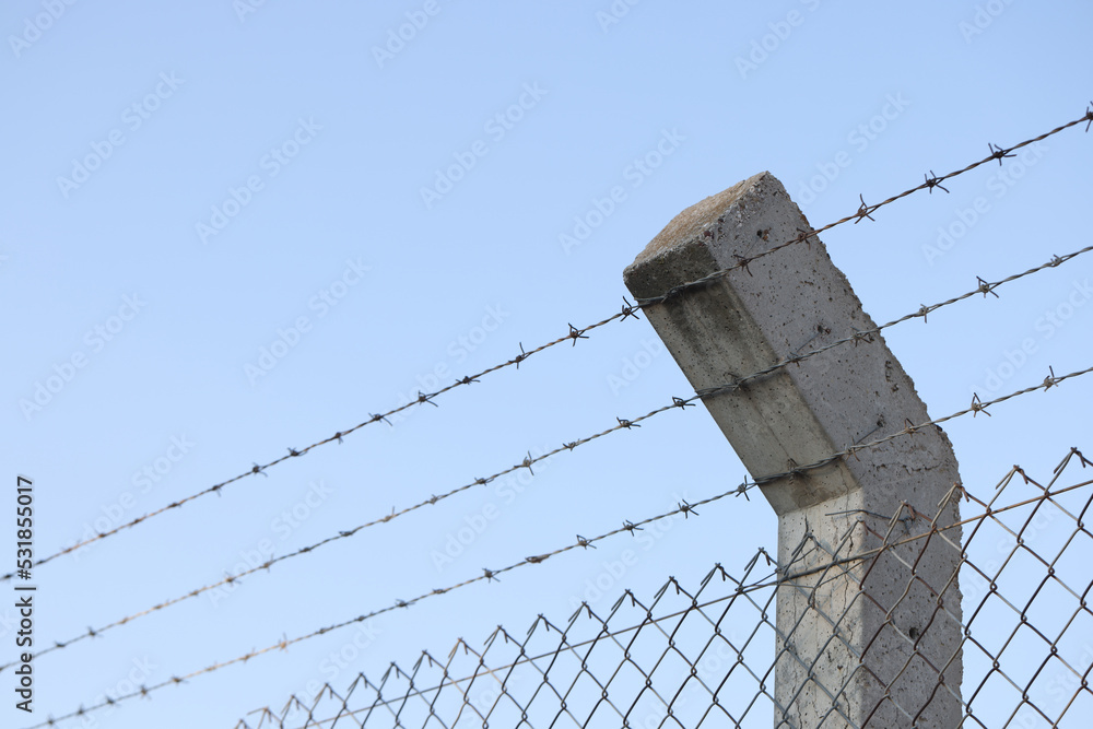 Fototapeta premium Barbed wire and blue sky in background
