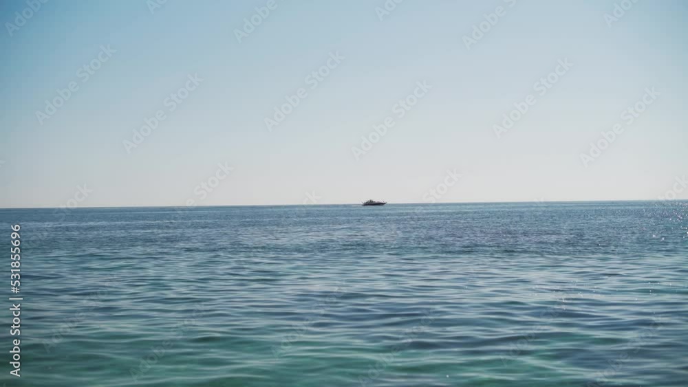 Seascape with a yacht on the horizon. Yacht at sea in the sun on a summer day. Seascape with a yacht on the horizon. Yacht at sea in the sun on a summer day.