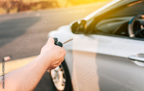 Close-up of driver outside car holding keys. Driver hands showing the car keys, Driver hands showing the keys outside the vehicle, Vehicle rental concept