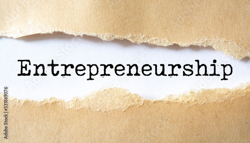 Entrepreneurship word written under torn paper.